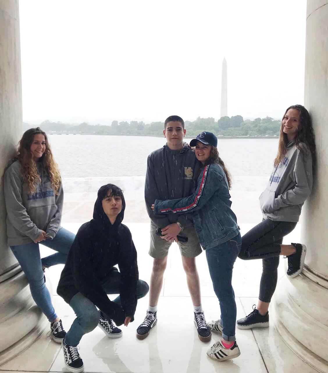 Cinco adolescentes, posando para foto y de fondo el obelisco del monumento a Washington.