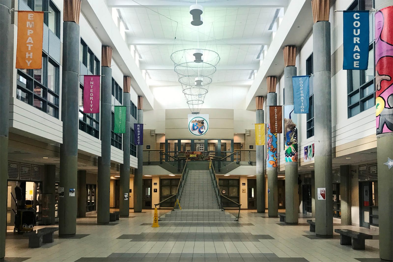 Hall principal de instituto, Canadá, con banderolas y valores