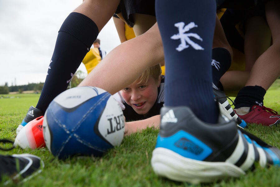 cara de chico jugando a rugby entre pies
