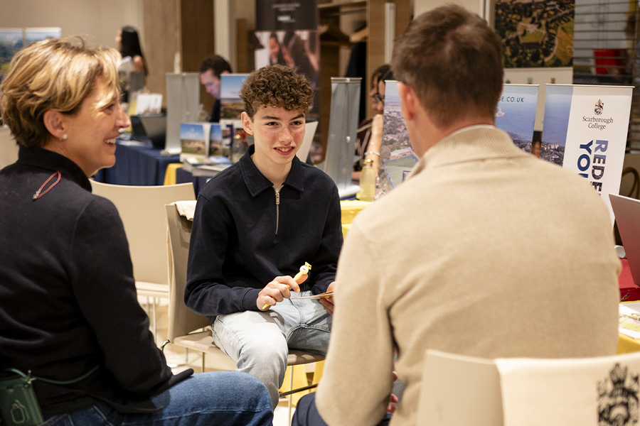 Representante de colegio británico hablando con familias interesadas en su programa para estudiantes internacionales