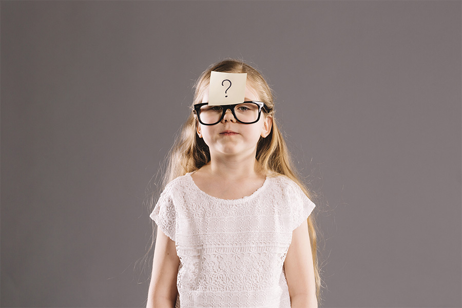 Niña con una nota adhesiva de interrogación en la frente, simbolizando la búsqueda de identidad y autoconocimiento.
